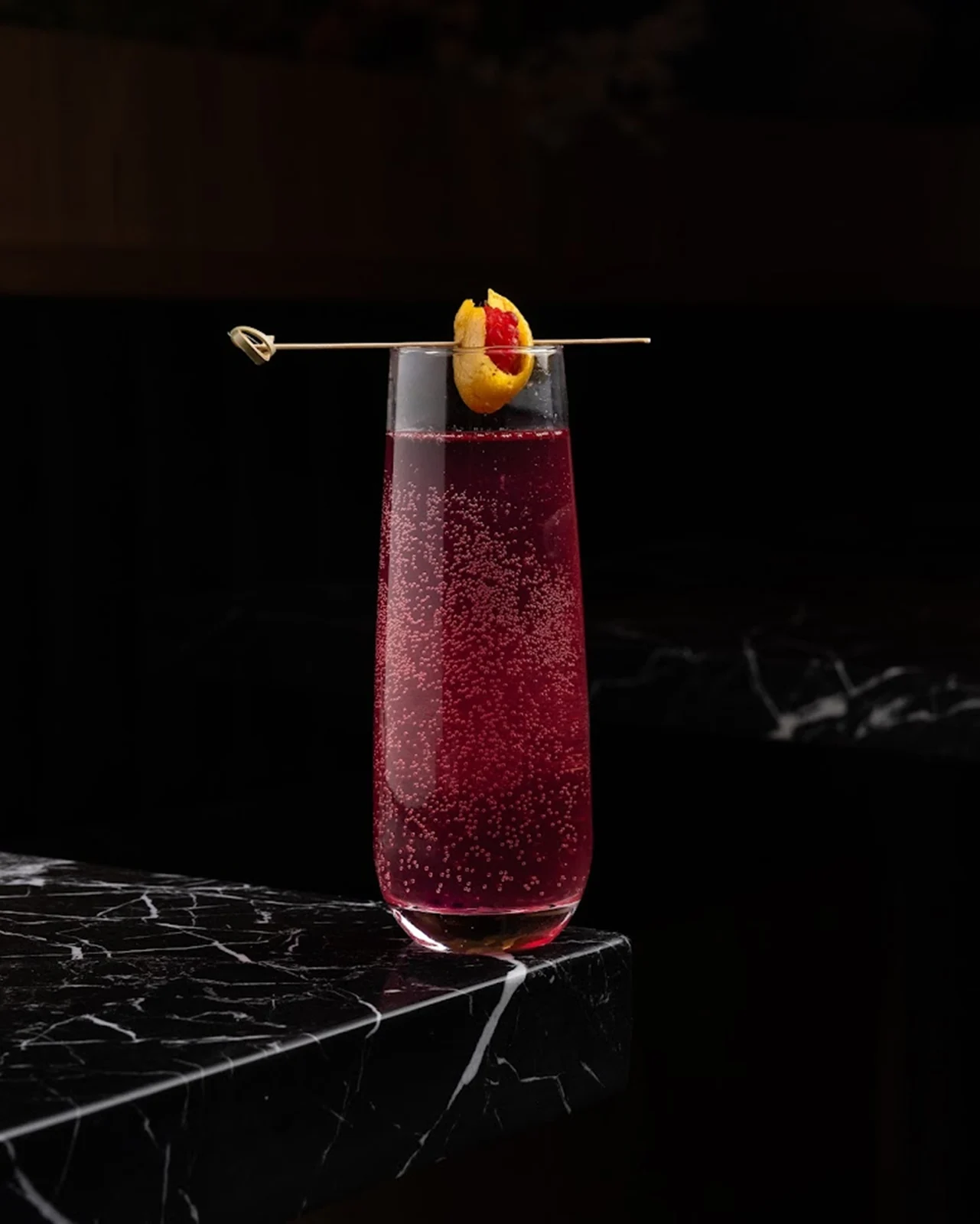 A jewel-toned Churasuko cocktail with citrus garnish