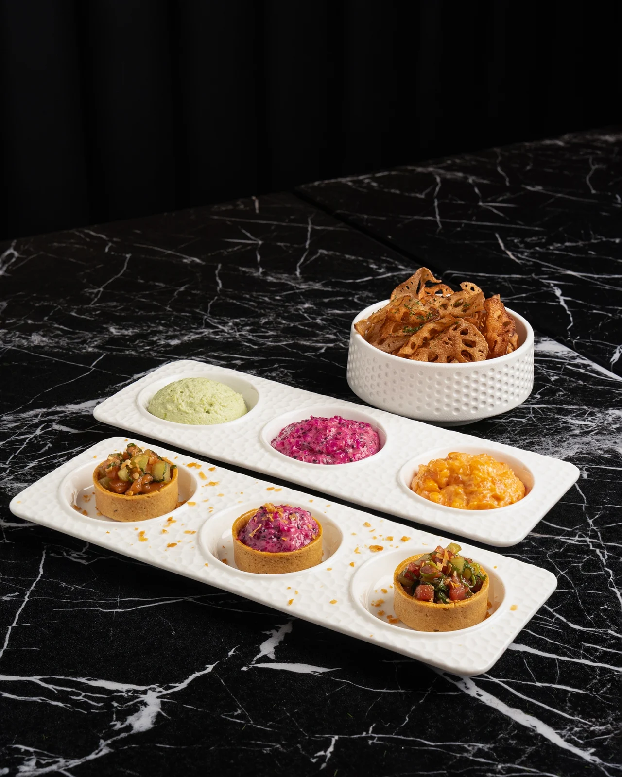 A selection of colorful appetizers and crisp lotus-root chips at Churasuko